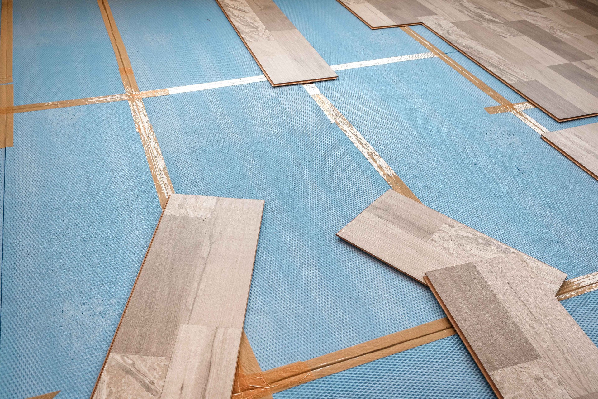Installing laminate flooring in a room or office. Wooden parquet boards background and tools. Construction and decorative works for the finishing of housing